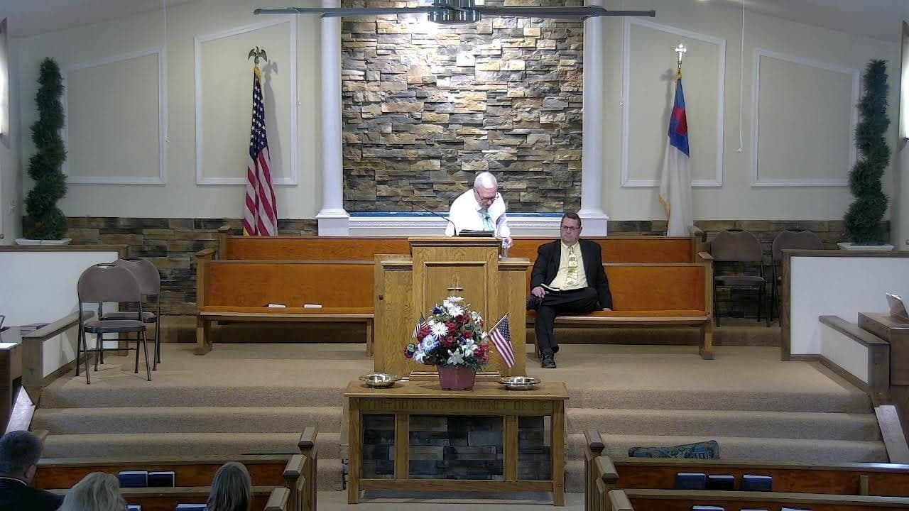 The auditorium at Countryside Baptist Church viewed from the congregation, with families seated in the oak pews.